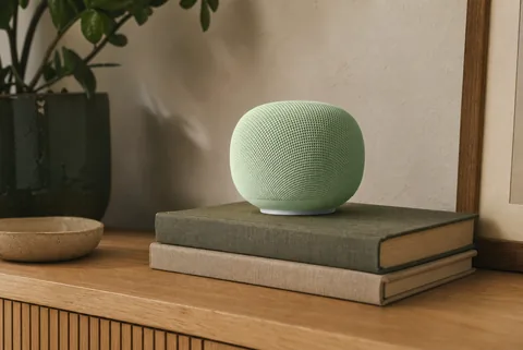 Google Home Speaker 2026 in pale sage fabric on a warm oak living-room console