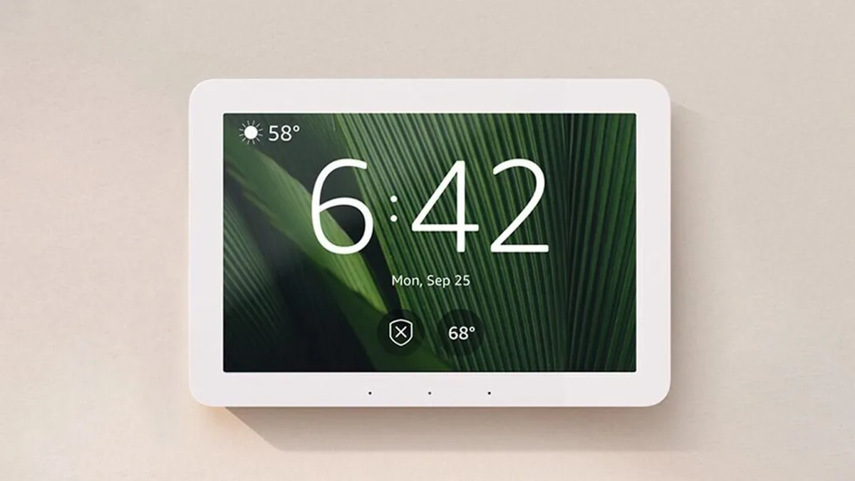 Amazon Echo Hub mounted on a warm beige wall with a dark-green leaf display