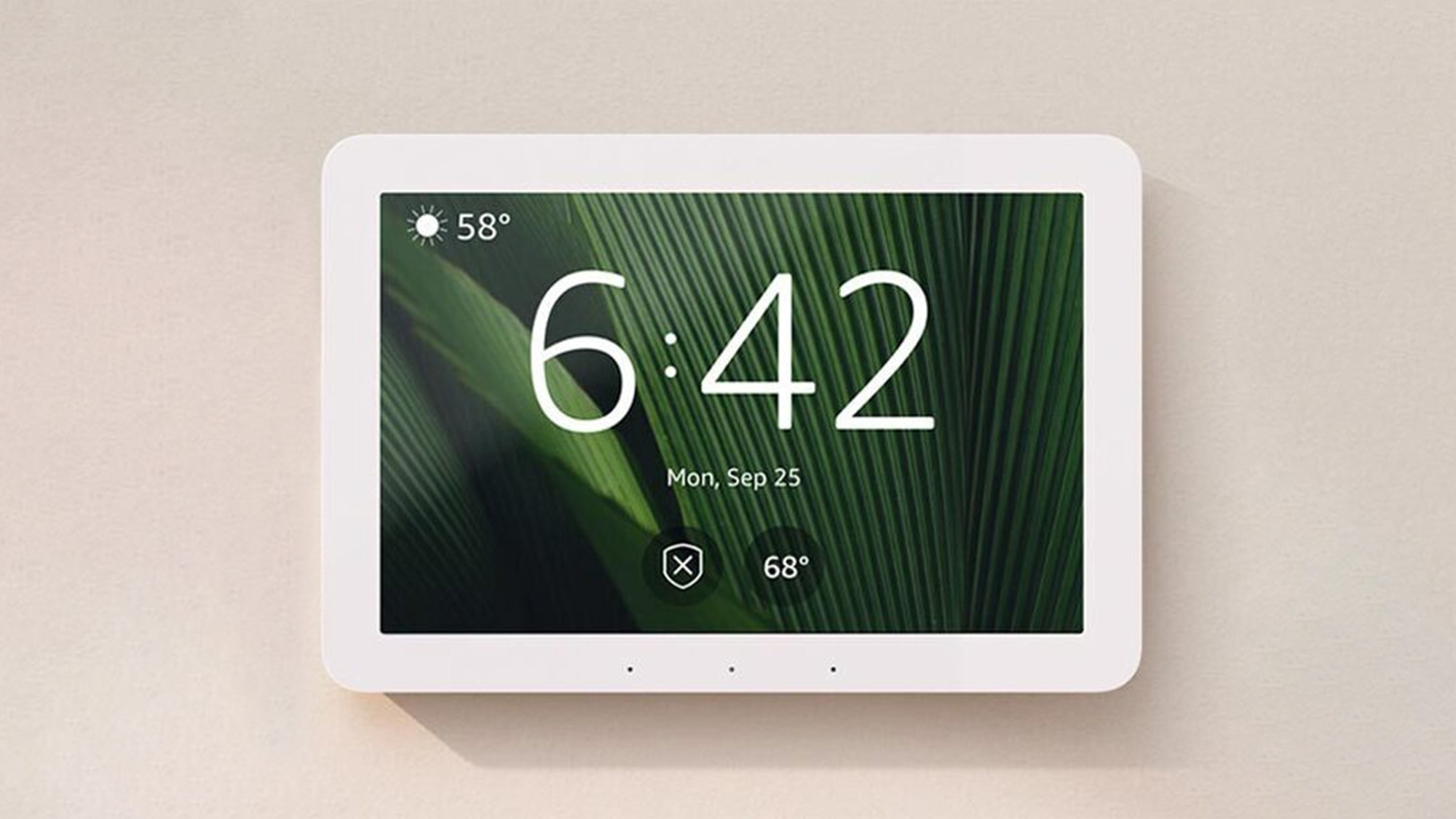 Amazon Echo Hub mounted on a warm beige wall with a dark-green leaf display