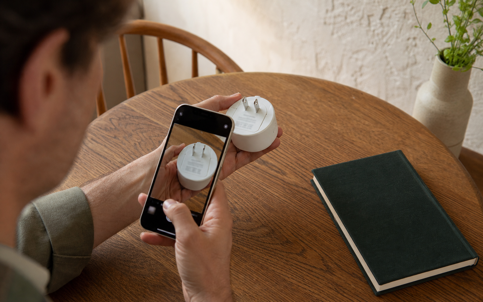 A homeowner photographing the setup label on the underside of a smart plug before installation